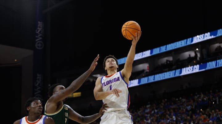 Nov 4, 2024; Jacksonville, Florida, USA; Florida Gators guard Walter Clayton Jr. (1) makes a layup under pressure from South Florida Bulls forward Jamille Reynolds (2) during the second half at VyStar Veterans Memorial Arena. Mandatory Credit: Morgan Tencza-Imagn Images
