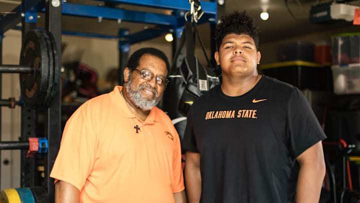 Stillwater offensive lineman JaKobe Sanders and his grandfather, Robert Turner, are pictured in Sanders    home gym on July 15.
super30 -- jump1 Stillwater offensive lineman JaKobe Sanders and his grandfather, Robert Turner, are pictured in Sanders    home gym on July 15.
super30 -- jump1