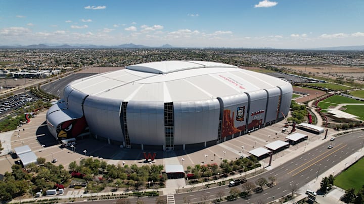 Workers install logos on the exterior of State Farm Stadium in preparation for the Final Four on April 6-8, 2024.
