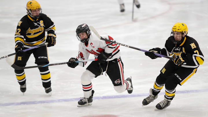 Neenah/Hortonville/Menasha Rockets' Ty Laabs (44) splits Ashwaubenon's Mitchell Specht (12) and Cade Dorn (7) during their boys hockey game Thursday, January 16, 2025, at Community First Championship Center in Grand Chute, Wisconsin. Ashwaubenon won 4-2.