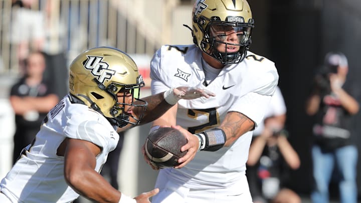 Nov 15, 2025; Lubbock, Texas, USA;  Central Florida Knights quarterback Tayven Jackson (2) hands the ball to running back Jaden Nixon (5) in the first half at Jones AT&T Stadium. Mandatory Credit: Michael C. Johnson-Imagn Images