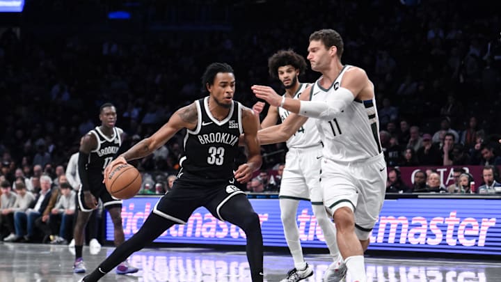 Dec 8, 2024; Brooklyn, New York, USA; Brooklyn Nets center Nic Claxton (33) drives to the basket while being defended by Milwaukee Bucks center Brook Lopez (11) during the first half at Barclays Center. Mandatory Credit: John Jones-Imagn Images