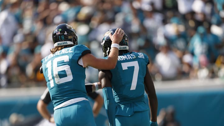 Oct 27, 2024; Jacksonville, Florida, USA; Jacksonville Jaguars quarterback Trevor Lawrence (16) and wide receiver Brian Thomas Jr. (7) celebrate a touchdown against the Green Bay Packers during the third quarter at EverBank Stadium. Mandatory Credit: Morgan Tencza-Imagn Images