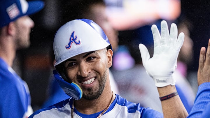 Atlanta Braves outfielder Eddie Rosario (8) celebrates in the dugout after hitting a home run against the St. Louis Cardinals during the sixth inning at Truist Park in 2024.