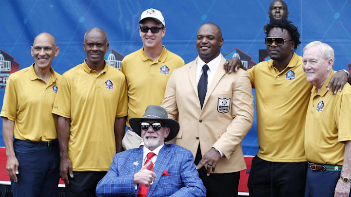 Aug 3, 2024; Canton, OH, USA; Pro Football Hall of Fame Class of 2024 member Dwight Freeney poses with his bust and former teammates coaches and his presenter Colts owner Jim Irsay (front) at his enshrinement ceremony at Tom Benson Hall of Fame Stadium. Mandatory Credit: Charles LeClaire-Imagn Images Aug 3, 2024; Canton, OH, USA; Pro Football Hall of Fame Class of 2024 member Dwight Freeney poses with his bust and former teammates coaches and his presenter Colts owner Jim Irsay (front) at his enshrinement ceremony at Tom Benson Hall of Fame Stadium. Mandatory Credit: Charles LeClaire-Imagn Images