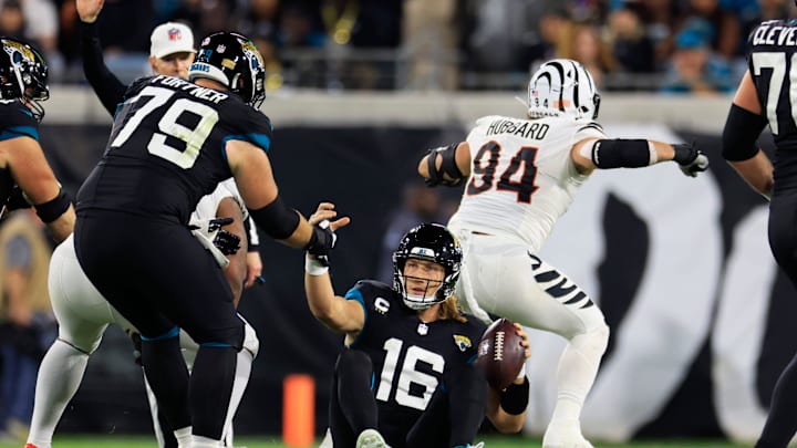 Jacksonville Jaguars quarterback Trevor Lawrence (16) is helped up by center Luke Fortner (79) after