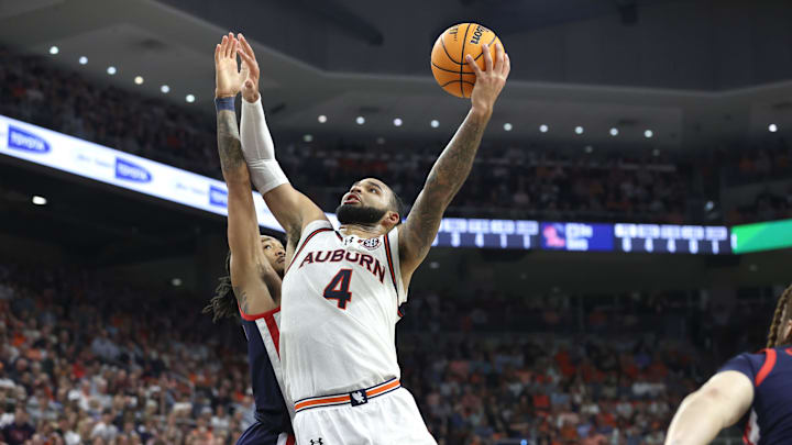 Feb 26, 2025; Auburn, Alabama, USA;  Auburn Tigers center Johni Broome (4) goes for a shot as Mississippi Rebels guard Dre Davis (14) defends during the second half at Neville Arena. Mandatory Credit: John Reed-Imagn Images