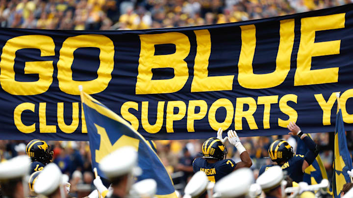 Sep 28, 2019; Ann Arbor, MI, USA; Michigan Wolverines linebacker Khaleke Hudson (7) and quarterback Shea Patterson (2) jump and touch the banner before the game against the Rutgers Scarlet Knights at Michigan Stadium. Mandatory Credit: Raj Mehta-Imagn Images