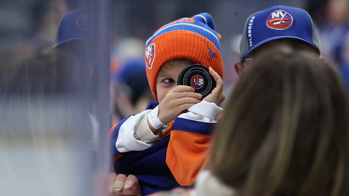 Apr 24, 2022; Elmont, New York, USA; A young fan gets a puck before the New York Islanders vs Carolina Hurricanes game at UBS Arena. Mandatory Credit: Thomas Salus-USA TODAY Sports Apr 24, 2022; Elmont, New York, USA; A young fan gets a puck before the New York Islanders vs Carolina Hurricanes game at UBS Arena. Mandatory Credit: Thomas Salus-USA TODAY Sports