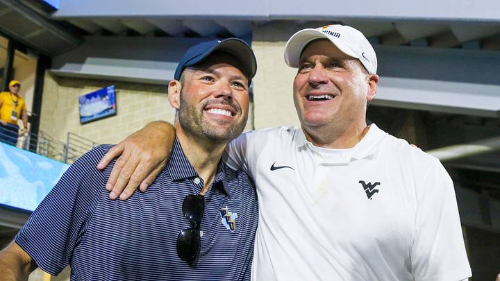 Sep 13, 2025; Morgantown, West Virginia, USA; West Virginia Mountaineers head coach Rich Rodriguez celebrates with West Virginia University athletic director Wren Baker after defeating the Pittsburgh Panthers at Milan Puskar Stadium. Mandatory Credit: Ben Queen-Imagn Images