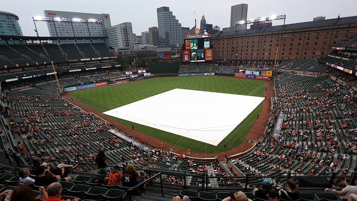 Jun 13, 2025; Baltimore, Maryland, USA; The Baltimore Orioles grounds crew puts down the tarp during a rain delay before a game against the Los Angeles Angels at Oriole Park at Camden Yards. Mandatory Credit: Daniel Kucin Jr.-Imagn Images