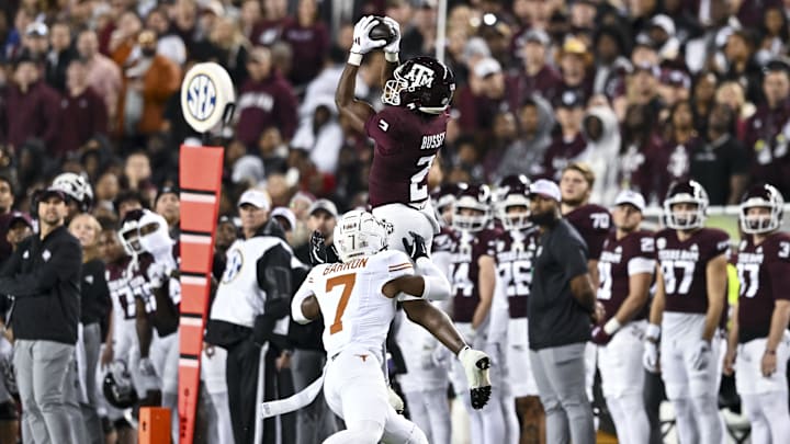 Nov 30, 2024; College Station, Texas, USA; Texas A&M Aggies wide receiver Terry Bussey (2) leaps to catch a pass over Texas Longhorns defensive back Jahdae Barron (7) during the first half. The Longhorns defeated the Aggies 17-7 at Kyle Field. Mandatory Credit: Maria Lysaker-Imagn Images  