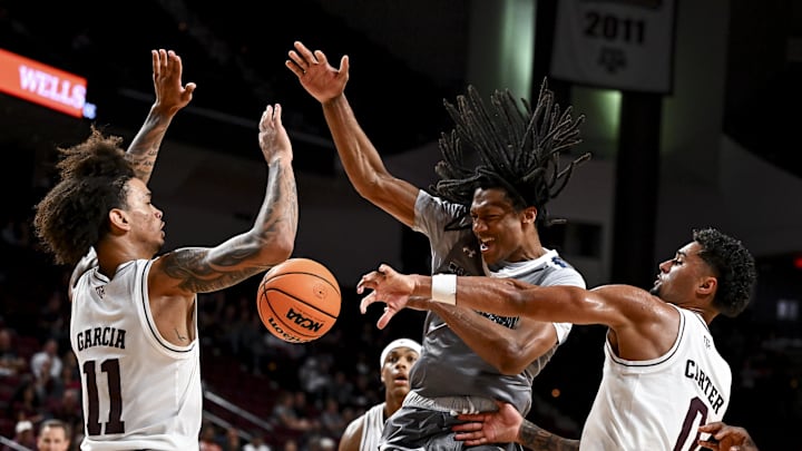 Nov 8, 2024; College Station, Texas, USA; Texas A&M Aggies guard Jace Carter (0) fouls East Texas A&M Lions forward Josh Taylor (24) during the second half at Reed Arena. The Aggies defeated the Lions 87-55. Mandatory Credit: Maria Lysaker-Imagn Images 