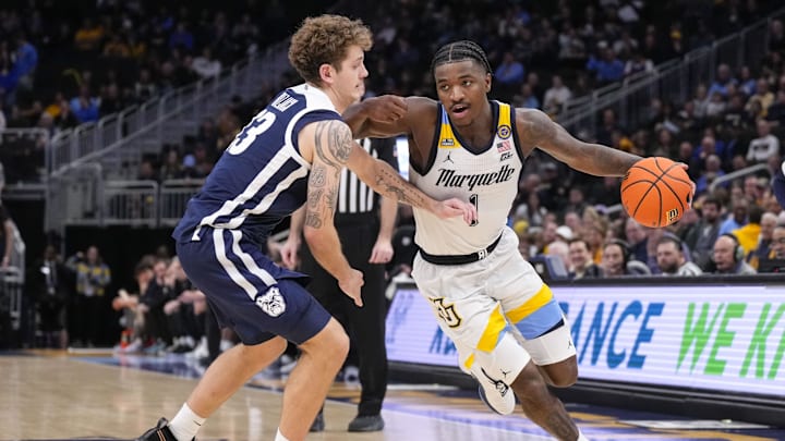 Dec 18, 2024; Milwaukee, Wisconsin, USA;  Marquette Golden Eagles guard Kam Jones (1) drives for the basket against Butler Bulldogs guard Finley Bizjack (13) during the second half at Fiserv Forum. Mandatory Credit: Jeff Hanisch-Imagn Images