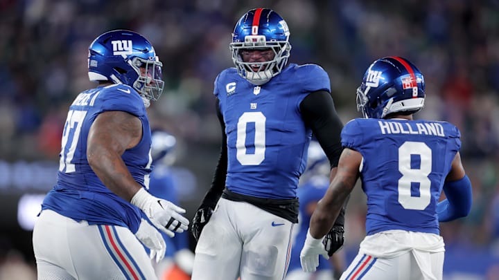 Oct 9, 2025; East Rutherford, New Jersey, USA; New York Giants linebacker Brian Burns (0) celebrates his sack of Philadelphia Eagles quarterback Jalen Hurts (not pictured) with defensive tackle Dexter Lawrence (97) and safety Jevon Holland (8) during the first quarter at MetLife Stadium.  