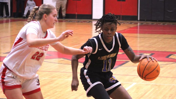 Rickards guard Genesis Henry (11) dribbles as Bishop Kenny guard Kathleen Crawley (22) defends during the FHSAA Region 1-4A high school girls basketball final on Feb. 21, 2025. [Clayton Freeman/Florida Times-Union]