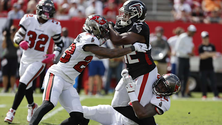 Oct 9, 2022; Tampa, Florida, USA; Atlanta Falcons running back Caleb Huntley (42) runs with the ball as Tampa Bay Buccaneers cornerback Jamel Dean (35) and safety Mike Edwards (32) tackle during the second half at Raymond James Stadium. Mandatory Credit: Kim Klement-Imagn Images