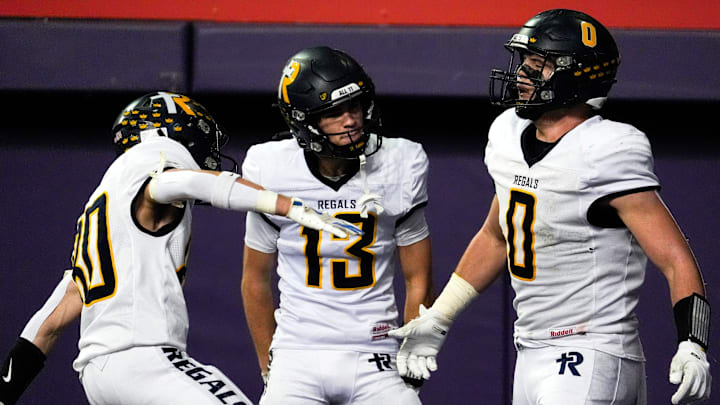 Iowa City Regina’s Tate Wallace (0) celebrates with teammates after scoring a touchdown Nov. 20, 2025 during the Class 1A state football championship against the West Lyon Wildcats at the UNI-Dome in Cedar Falls, Iowa.