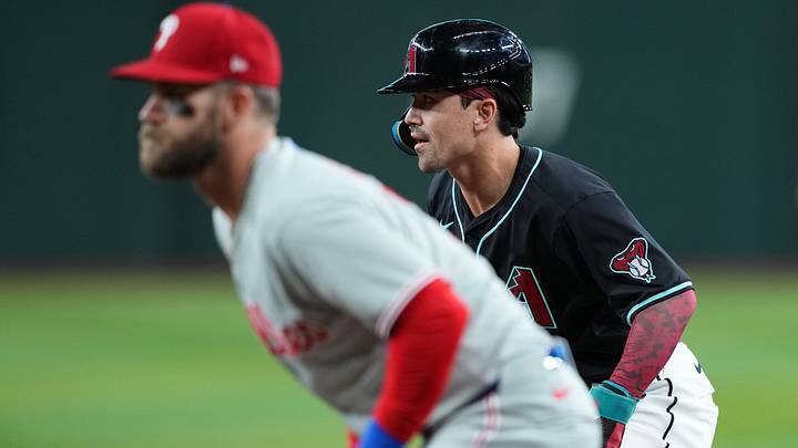 Sep 20, 2025; Phoenix, Arizona, USA; Arizona Diamondbacks outfielder Corbin Carroll (7) leads off first base as Philadelphia Phillies first base Bryce Harper (3) covers the bag during the first inning at Chase Field. Mandatory Credit: Joe Camporeale-Imagn Images