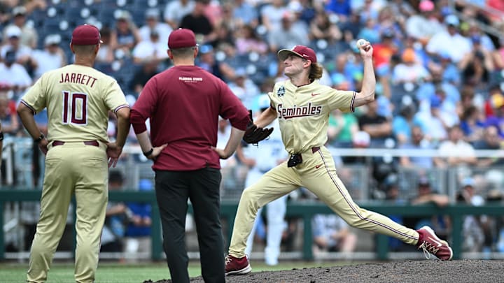 Jun 18, 2024; Omaha, NE, USA; Florida State Seminoles starting pitcher Andrew Armstrong (37) takes a warm up throw as  head coach Link Jarrett looks on during the second inning against the North Carolina Tar Heels at Charles Schwab Field Omaha. Mandatory Credit: Steven Branscombe-Imagn Images
