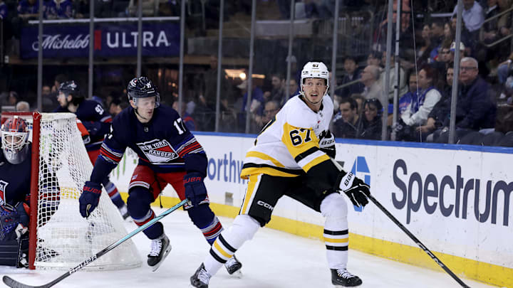 Feb 7, 2025; New York, New York, USA; Pittsburgh Penguins right wing Rickard Rakell (67) plays the puck against New York Rangers defenseman Will Borgen (17) during the first period at Madison Square Garden. Mandatory Credit: Brad Penner-Imagn Images