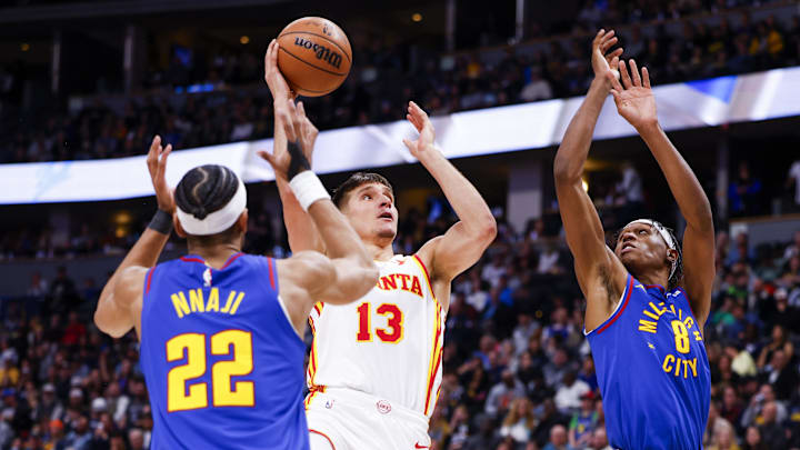 Apr 6, 2024; Denver, Colorado, USA; Atlanta Hawks guard Seth Lundy (3) takes a shot past Denver Nuggets forward Zeke Nnaji (22) and forward Peyton Watson (8) in the second half at Ball Arena. Mandatory Credit: Michael Ciaglo-Imagn Images