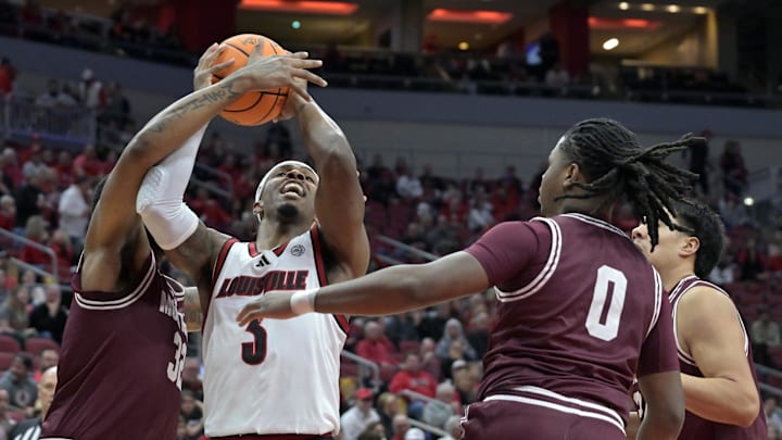 Dec 20, 2025; Louisville, Kentucky, USA;  Louisville Cardinals guard Ryan Conwell (3) drives to the basket against Montana Grizzlies forward Te'Jon Sawyer (32) and guard Money Williams (0) during the first half at KFC Yum! Center. Mandatory Credit: Jamie Rhodes-Imagn Images