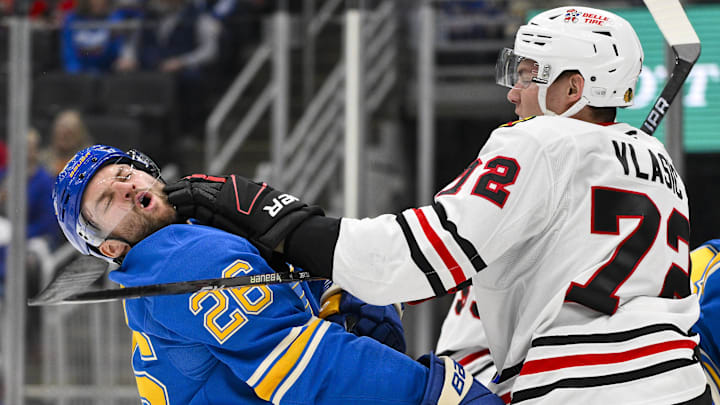 Mar 22, 2025; St. Louis, Missouri, USA;  Chicago Blackhawks defenseman Alex Vlasic (72) punches St. Louis Blues left wing Nathan Walker (26) during the second period at Enterprise Center. Mandatory Credit: Jeff Curry-Imagn Images