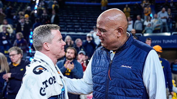 Michigan head coach Dusty May, left, is congratulated by athletic director Warde Manuel after 75-72 win over Nebraska at Crisler Center in Ann Arbor on Tuesday, Jan. 27, 2026.