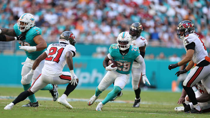 Dec 28, 2025; Miami Gardens, Florida, USA; Miami Dolphins running back De'Von Achane (28) runs for a gain past Tampa Bay Buccaneers cornerback Benjamin Morrison (21) during the third quarter at Hard Rock Stadium. Mandatory Credit: Nathan Ray Seebeck-Imagn Images