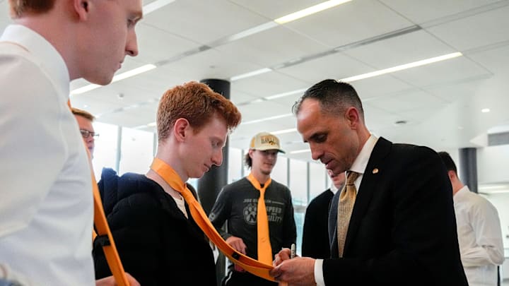 Iowa head men's basketball coach Ben McCollum signs the tie of a Hawks Nest member after his introductory press conference Tuesday, March 25, 2025 at Carver-Hawkeye Arena in Iowa City, Iowa.