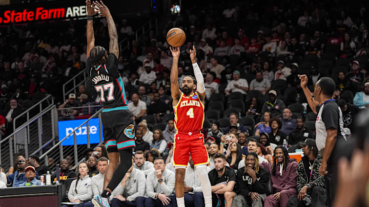 Mar 23, 2026; Atlanta, Georgia, USA; Atlanta Hawks guard Gabe Vincent (4) shoots over Memphis Grizzlies guard DeJon Jarreau (77) during the second half at State Farm Arena. Mandatory Credit: Dale Zanine-Imagn Images