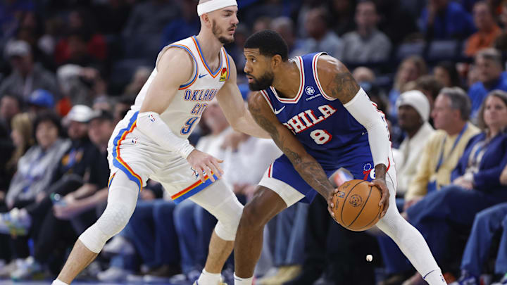 Dec 28, 2025; Oklahoma City, Oklahoma, USA; Philadelphia 76ers forward Paul George (8) moves the ball as Oklahoma City Thunder guard Alex Caruso (9) defends during the second half at Paycom Center. Mandatory Credit: Alonzo Adams-Imagn Images