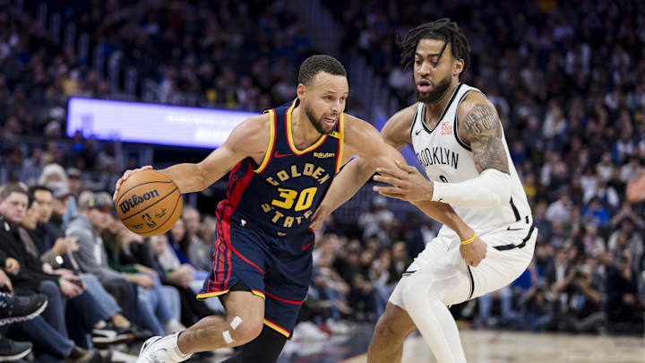 Nov 25, 2024; San Francisco, California, USA;  Golden State Warriors guard Stephen Curry (30) drives past Brooklyn Nets forward Trendon Watford (9) during the second half at Chase Center. Mandatory Credit: John Hefti-Imagn Images