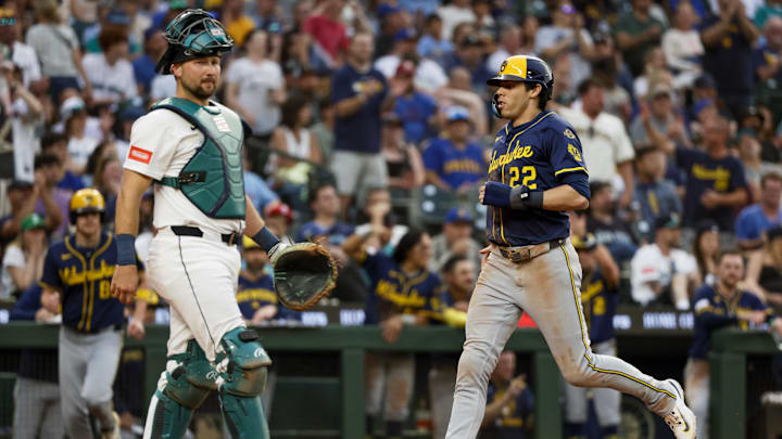 Jul 21, 2025; Seattle, Washington, USA; Milwaukee Brewers designated hitter Christian Yelich (22) scores a run against Seattle Mariners catcher Cal Raleigh (29) during the seventh inning at T-Mobile Park. Mandatory Credit: Joe Nicholson-Imagn Images
