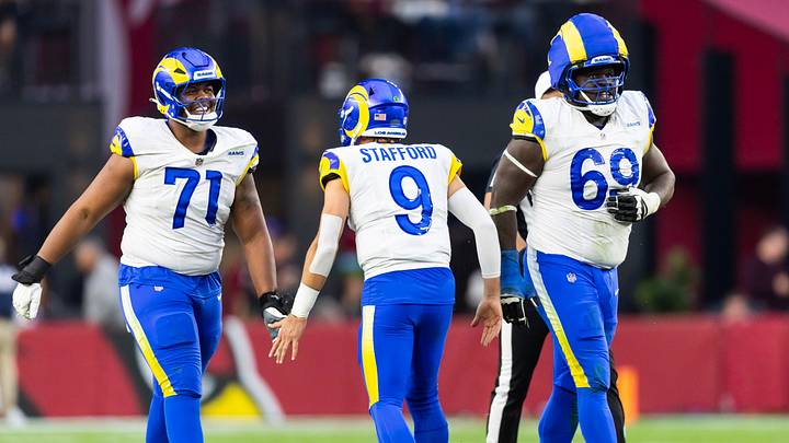 Dec 7, 2025; Glendale, Arizona, USA; Los Angeles Rams quarterback Matthew Stafford (9) celebrates a touchdown with offensive lineman Warren McClendon Jr. (71) and Kevin Dotson (69) against the Arizona Cardinals at State Farm Stadium. Mandatory Credit: Mark J. Rebilas-Imagn Images Dec 7, 2025; Glendale, Arizona, USA; Los Angeles Rams quarterback Matthew Stafford (9) celebrates a touchdown with offensive lineman Warren McClendon Jr. (71) and Kevin Dotson (69) against the Arizona Cardinals at State Farm Stadium. Mandatory Credit: Mark J. Rebilas-Imagn Images