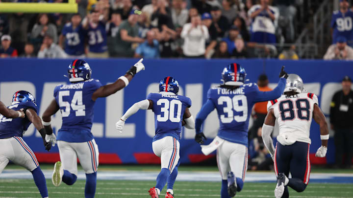 Aug 21, 2025; East Rutherford, New Jersey, USA; New York Giants cornerback TJ Moore (30) returns an interception for a touchdown during the second half against the New England Patriots at MetLife Stadium.  