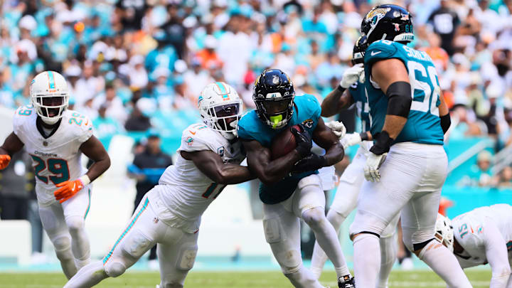 Sep 8, 2024; Miami Gardens, Florida, USA; Jacksonville Jaguars running back Tank Bigsby (4) runs with the football against Miami Dolphins linebacker David Long Jr. (11) during the third quarter at Hard Rock Stadium. Mandatory Credit: Sam Navarro-Imagn Images