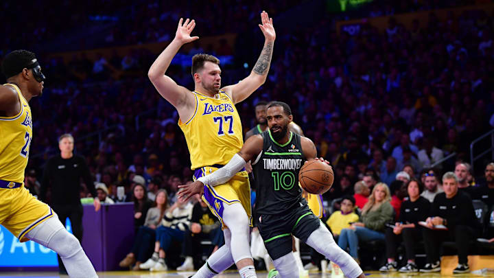 Apr 30, 2025; Los Angeles, California, USA; Minnesota Timberwolves guard Mike Conley (10) moves the ball against Los Angeles Lakers guard Luka Doncic (77) during the second half in game five of first round for the 2025 NBA Playoffs at Crypto.com Arena. Mandatory Credit: Gary A. Vasquez-Imagn Images