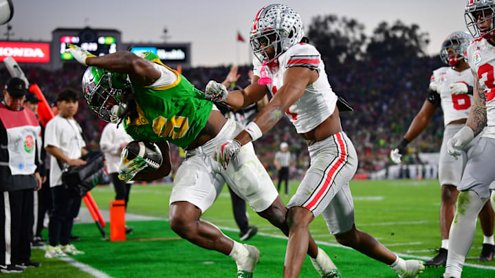 Jan 1, 2025; Pasadena, CA, USA;  Ohio State Buckeyes cornerback Davison Igbinosun (1) pushes Oregon Ducks running back Noah Whittington (6) out of bounds in the second half in the 2025 Rose Bowl college football quarterfinal game at Rose Bowl Stadium. Mandatory Credit: Gary A. Vasquez-Imagn Images