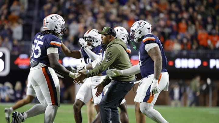 Nov 8, 2025; Charlottesville, Virginia, USA; Virginia Cavaliers head coach Tony Elliott (center) celebrates with players after a play against the Wake Forest Demon Deacons during the first half at Scott Stadium. Mandatory Credit: Amber Searls-Imagn Images