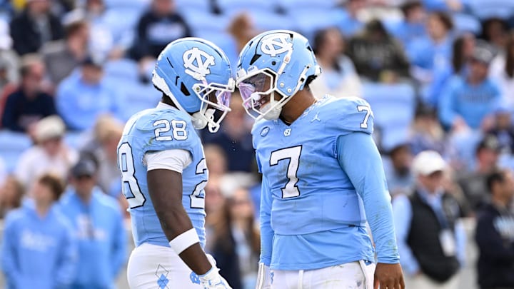 Oct 25, 2025; Chapel Hill, North Carolina, USA; North Carolina Tar Heels running back Benjamin Hall (28) with quarterback Gio Lopez (7) on the field in the third quarter at Kenan Stadium. Mandatory Credit: Bob Donnan-Imagn Images Oct 25, 2025; Chapel Hill, North Carolina, USA; North Carolina Tar Heels running back Benjamin Hall (28) with quarterback Gio Lopez (7) on the field in the third quarter at Kenan Stadium. Mandatory Credit: Bob Donnan-Imagn Images