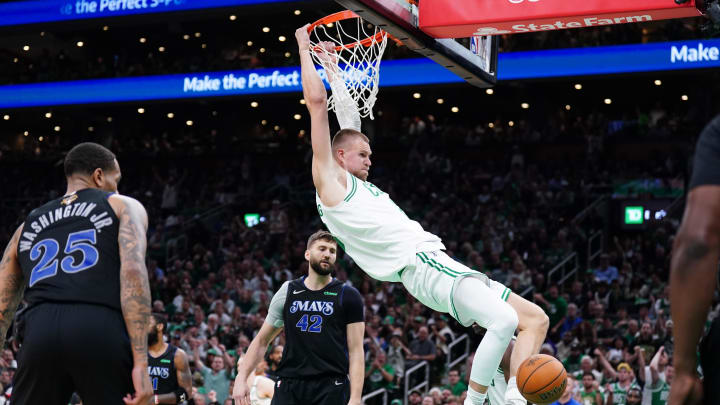 Jun 6, 2024; Boston, Massachusetts, USA; Boston Celtics center Kristaps Porzingis (8) dunks against Dallas Mavericks forward P.J. Washington (25) and forward Maxi Kleber (42) in the third quarter during game one of the 2024 NBA Finals at TD Garden. Mandatory Credit: David Butler II-USA TODAY Sports