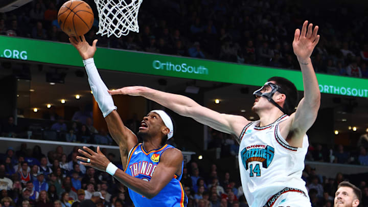 Feb 8, 2025; Memphis, Tennessee, USA; Oklahoma City Thunder guard Shai Gilgeous-Alexander (2) shoots as Memphis Grizzlies center Zach Edey (14) defends during the first quarter at FedExForum. Mandatory Credit: Petre Thomas-Imagn Images Feb 8, 2025; Memphis, Tennessee, USA; Oklahoma City Thunder guard Shai Gilgeous-Alexander (2) shoots as Memphis Grizzlies center Zach Edey (14) defends during the first quarter at FedExForum. Mandatory Credit: Petre Thomas-Imagn Images