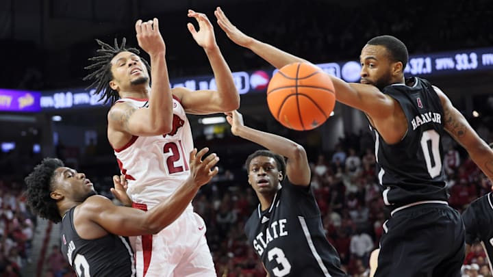 Mar 8, 2025; Fayetteville, Arkansas, USA; Arkansas Razorbacks guard D.J. Wagner (21) is fouled while driving between Mississippi State Bulldogs guard Josh Hubbard (12) and forward KeShawn Murphy (3) as guard Claudell Harris Jr (0) looks on during the first half at Bud Walton Arena. Mandatory Credit: Nelson Chenault-Imagn Images