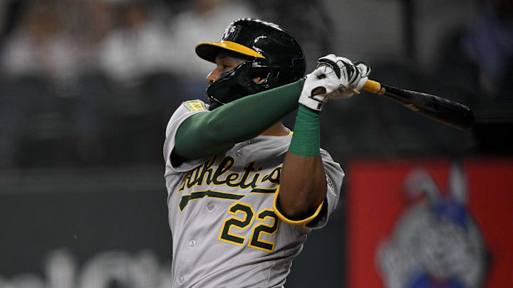 May 1, 2025; Arlington, Texas, USA; Athletics third baseman Miguel Andujar (22) hits a single and drives in a run against the Texas Rangers during the first inning at Globe Life Field. Mandatory Credit: Jerome Miron-Imagn Images