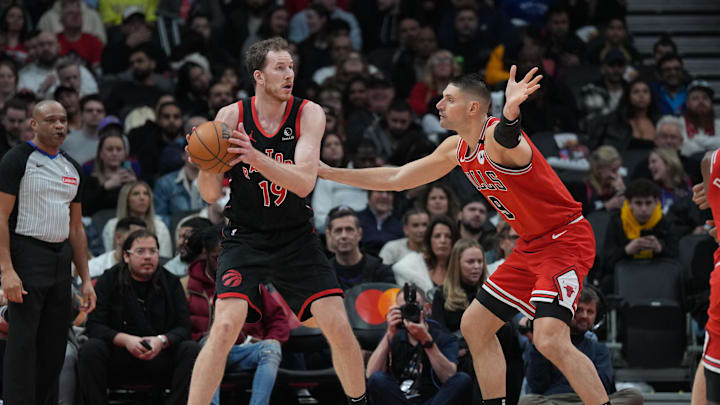 Jan 31, 2025; Toronto, Ontario, CAN: Toronto Raptors center Jakob Poeltl (19) controls the ball as Chicago Bulls center Nikola Vucevic (9) tries to defend during the third quarter at Scotiabank Arena. Mandatory Credit: Nick Turchiaro-Imagn Images