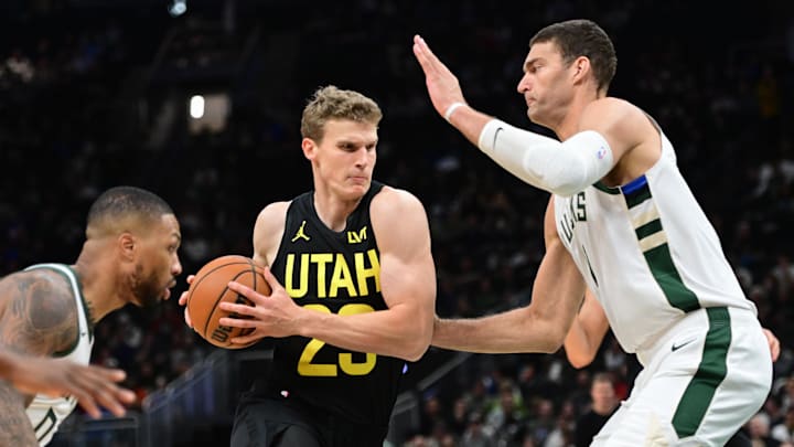 Nov 7, 2024; Milwaukee, Wisconsin, USA; Utah Jazz forward Lauri Markkanen (23) drives for the basket between Milwaukee Bucks guard Damian Lillard (0) and center Brook Lopez (11) in the first quarter at Fiserv Forum. Mandatory Credit: Benny Sieu-Imagn Images