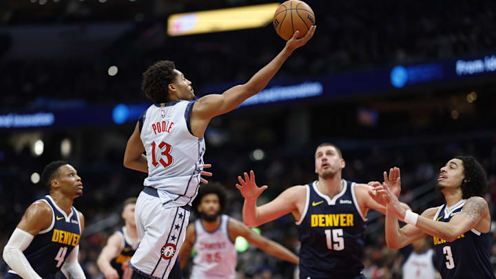 Dec 7, 2024; Washington, District of Columbia, USA; Washington Wizards guard Jordan Poole (13) shoots the ball as Denver Nuggets center Nikola Jokic (15) looks on in the third quarter at Capital One Arena. Mandatory Credit: Geoff Burke-Imagn Images