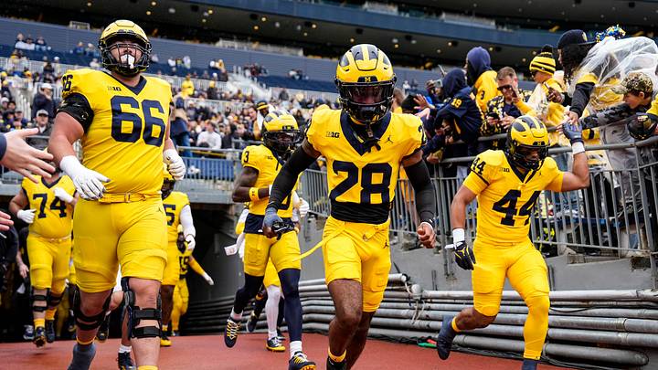 From left, Michigan offensive lineman Dan Taraboi (66), wide receiver I'Marion Stewart (28) and tight end Eli Owens (44) take the field for the spring game at Michigan Stadium in Ann Arbor on Saturday, April 18, 2026.